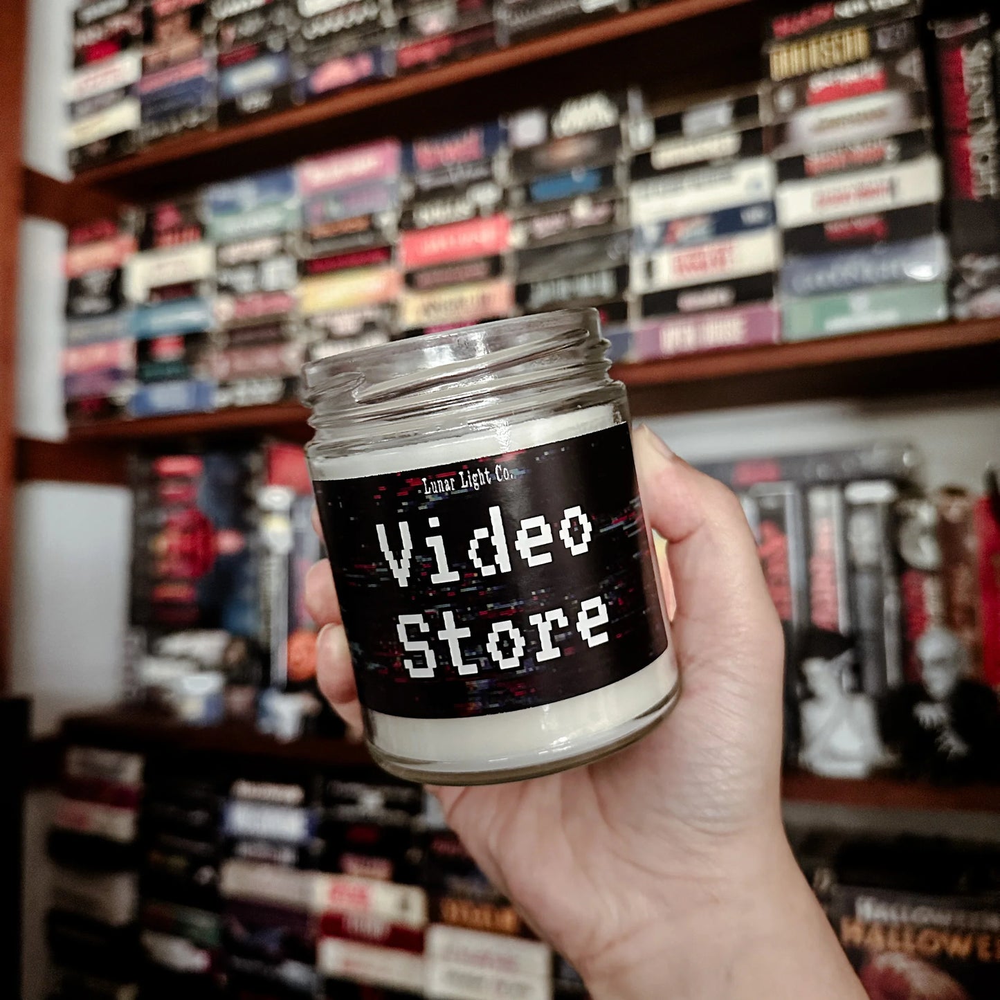 Video Store Candle in hand with VHS tapes in background
