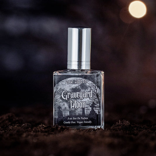 Graveyard Moon eau de parfum bottle displayed on dirt with a foggy, moonlit atmosphere