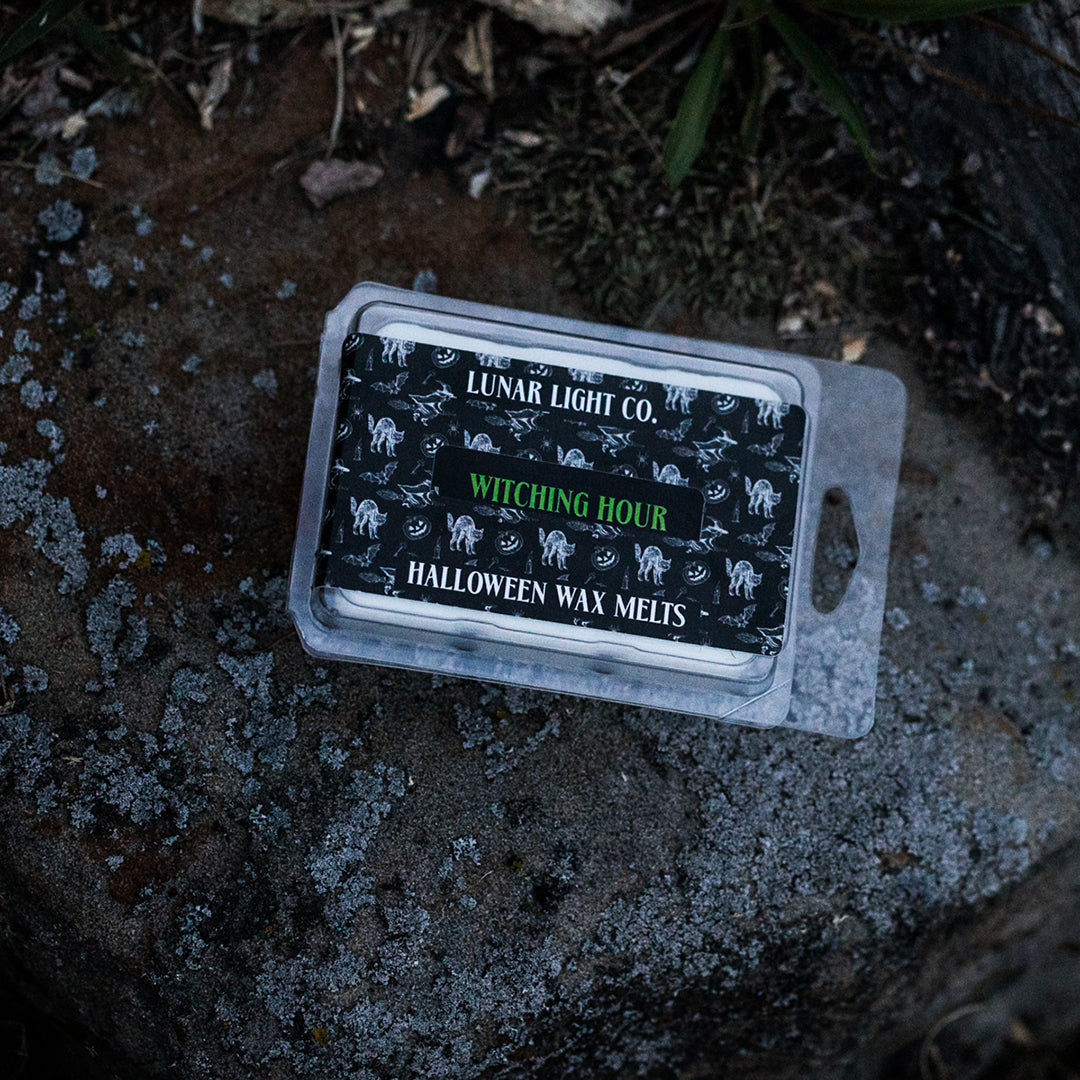 halloween wax melt displayed on a moss covered rock