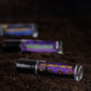 three perfume oil roll ons on dirt. halloween forever label is in focus