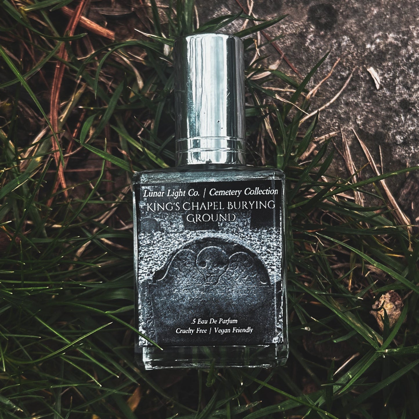 Kings Chapel Winged Skull Gravestone label on a gothic perfume displayed in grass