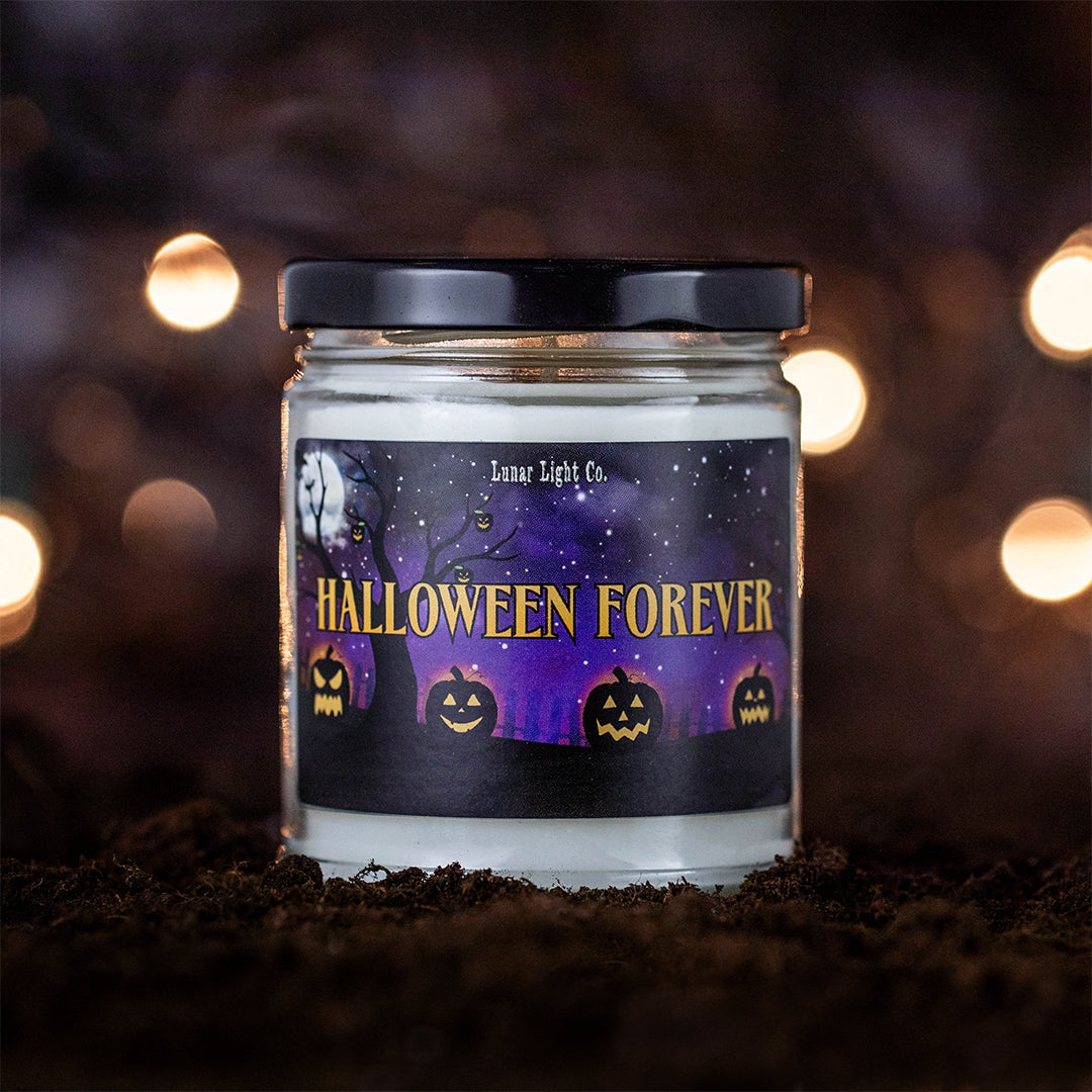 Halloween Forever  candle on dirt with bokeh lights in the foggy, mysterious background