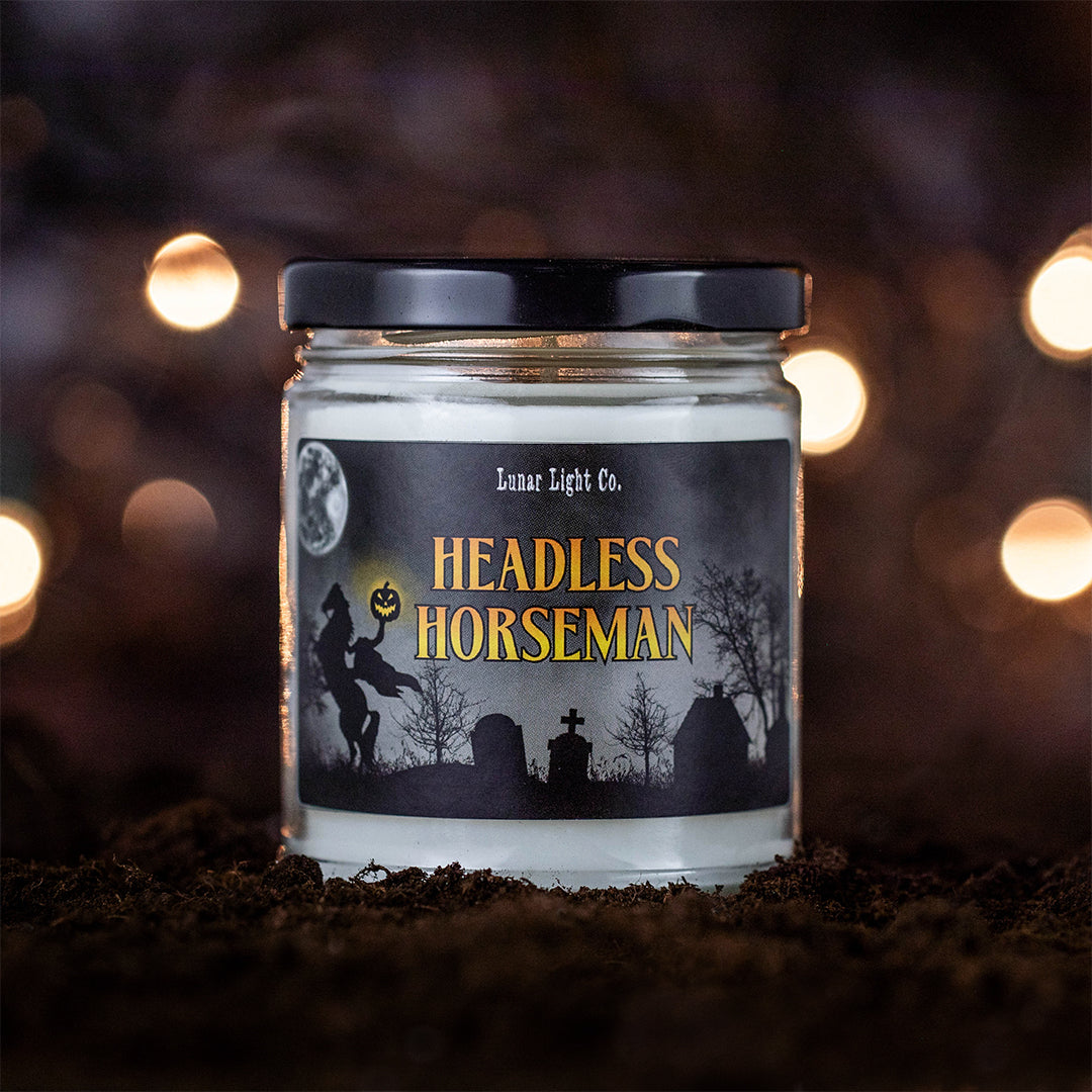 Headless Horseman candle on dirt with bokeh lights in the foggy, mysterious background