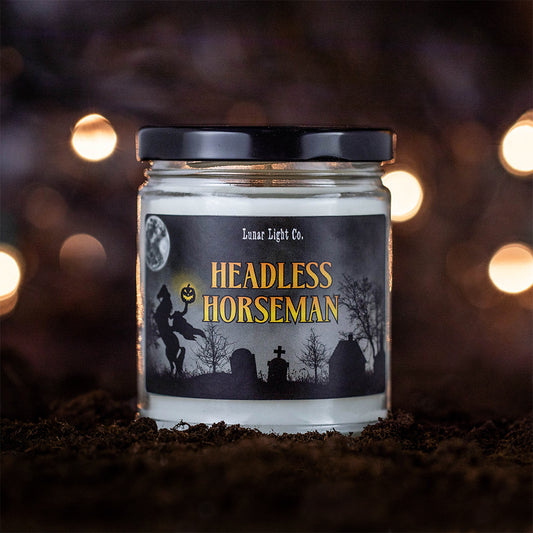 Headless Horseman candle on dirt with bokeh lights in the foggy, mysterious background