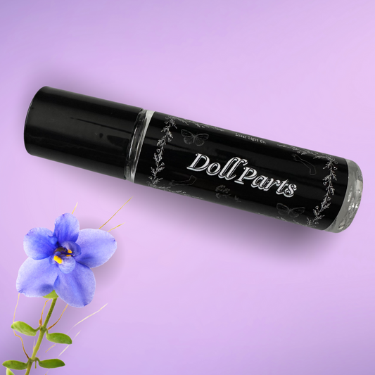 Doll Parts Perfume Oil with Violet flower on purple