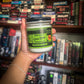 lunar light co movie night candle being held in front of vhs tapes on a shelf