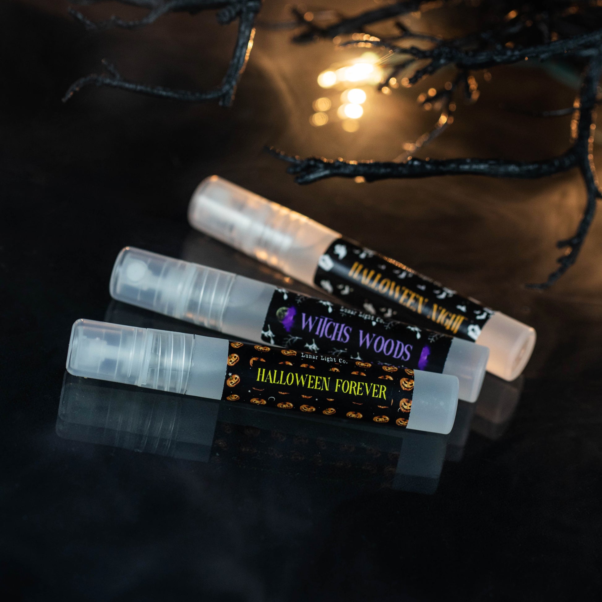 3 halloween travel sprays in clear bottle with spooky branches