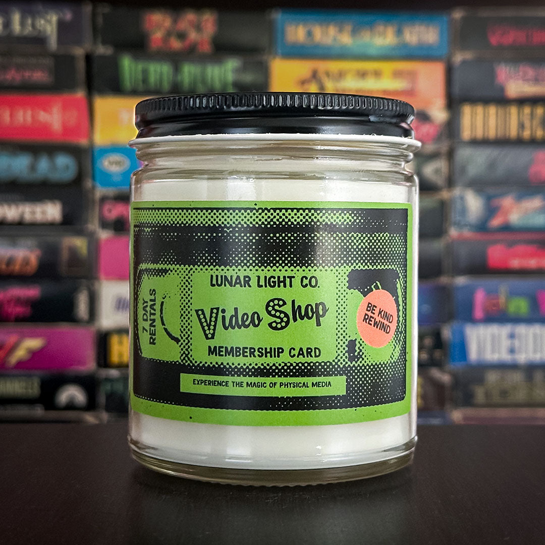 A nostalgic candle showing a VHS tape style membership card that would be common in video stores