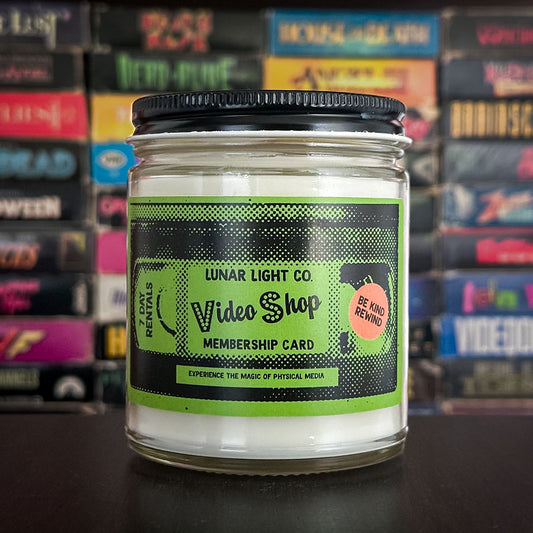 A nostalgic candle showing a VHS tape style membership card that would be common in video stores