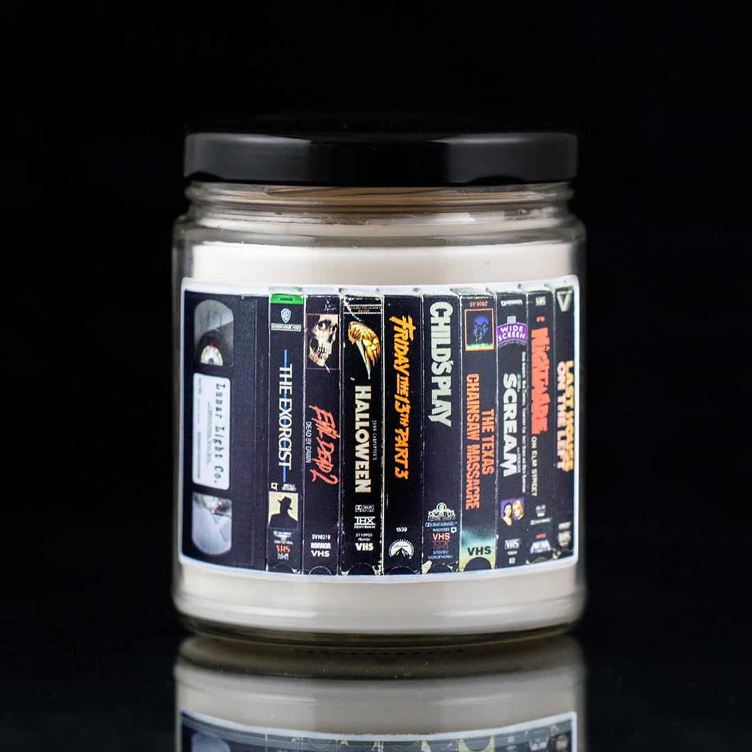 Classic horror vhs candle showing the Exorcist, Evil Dead 2, Halloween, Friday the 13th 3, Childs Play, Texas Chainsaw Massacre, Scream, Night on Elm Street, Last House on the Left