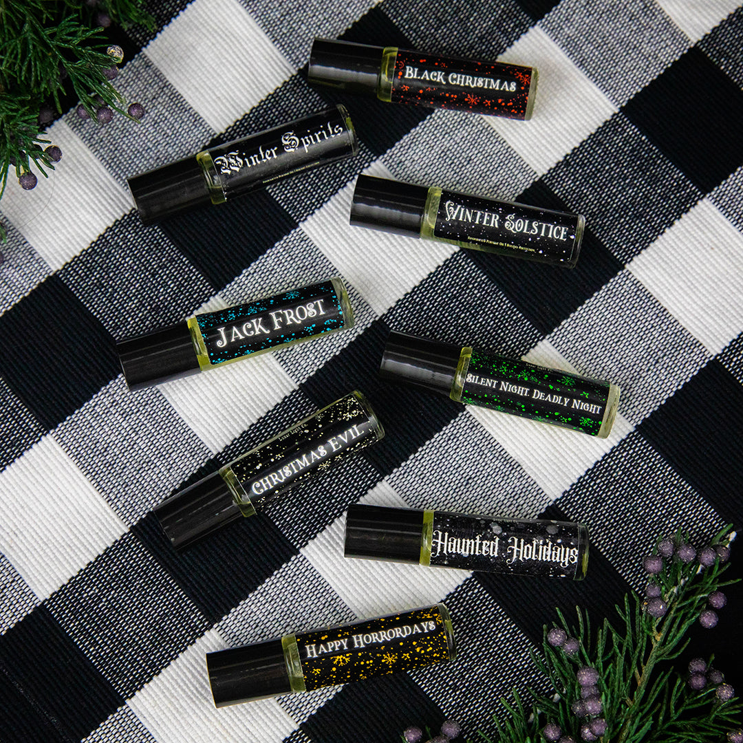 Haunted Holidays Perfume Roll on Collection on White and Black tablecloth