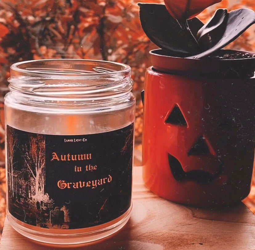 autumn in the graveyard candle with pumpkin and plant