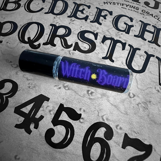 Witchboard perfume oil laying on ouija board